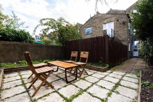 a patio with two chairs and a table and a fence at Lovely 2 Bedroom Garden Flat in London in London