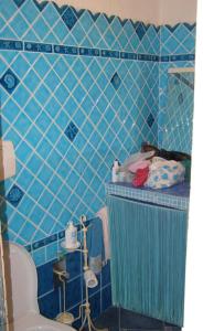 a blue tiled bathroom with a sink and a toilet at Appartamento Taras Sottovento - Porto Cervo in Abbiadori