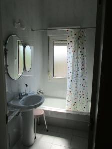 ein Bad mit einem Waschbecken und einem Duschvorhang in der Unterkunft MyHouseSpain -Xivares, Chalet con vistas al mar in Carrió