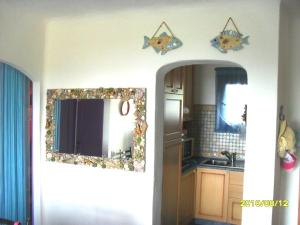 a kitchen with a mirror on the wall and a sink at Appartamento Taras Sottovento - Porto Cervo in Abbiadori