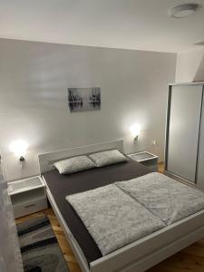 sypialnia z dużym łóżkiem i 2 szafkami nocnymi w obiekcie Apartman Samardžić w mieście Wiszegrad