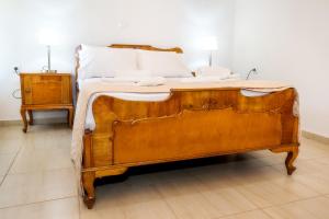a wooden bed in a room with a night stand at Casa Monte in Theologos