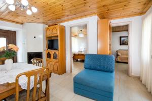 a living room with a table and a blue chair at Casa Monte in Theológos