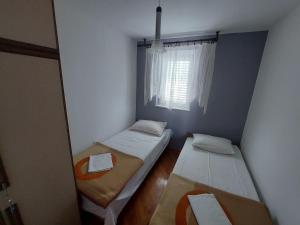 a small room with two beds and a window at Milka Apartments in Njivice