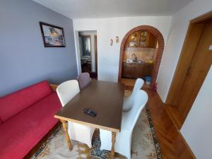 a living room with a table and a red couch at Milka Apartments in Njivice