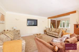 Farnborough - Grand 4 Bed Home في Cove: غرفة معيشة مع كنبتين وتلفزيون