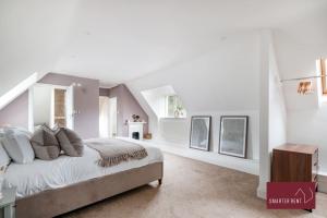 Farnborough - Grand 4 Bed Home في Cove: غرفة نوم بسرير كبير بجدران بيضاء وردية