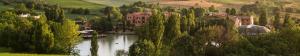 a river with houses and trees in a town at Hotel Villa Leri in Monte Colombo