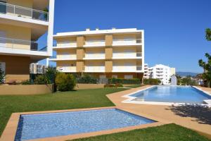 a swimming pool in front of a building at Apartamento Vila Arade in Portimão