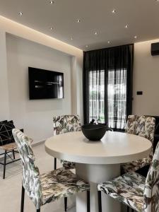 a dining room with a white table and chairs at Lagonisi Luxury Apartment by the sea in Lagonissi