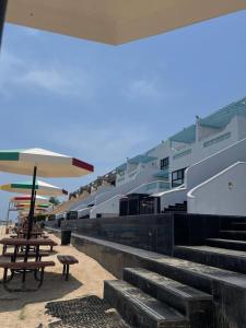 ein Gebäude mit einer Treppe, einem Picknicktisch und einem Sonnenschirm in der Unterkunft درة العروس استوديو على شاطئ البرادايس - عوائل in Durrat Al-Arus