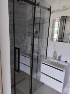 y baño con ducha acristalada y lavamanos. en Pensjonat na Wzgórzu en Solina