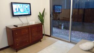 a living room with a tv and a dresser and a window at Paseo Victorica in Tigre