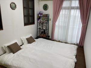 a bedroom with a large white bed in front of a window at 日式庭院豪宅 