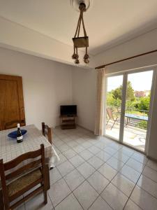 uma sala de jantar com uma mesa e vista para um pátio em Koulouras Holiday Apartments em Nikolaíika