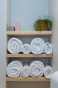 a bunch of rolled up towels on a shelf at Velouchi Hideout Residence in Tinos