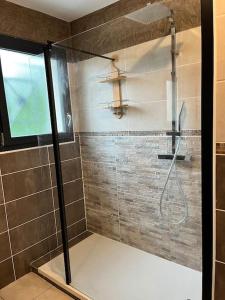 La salle de bains est pourvue d'une douche avec une porte en verre. dans l'établissement Charmante petite maison au cœur de Valergues, à Valergues