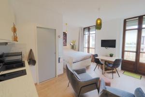 pokój hotelowy z łóżkiem, stołem i krzesłami w obiekcie Studio refait à neuf en hypercentre avec balcon w Aix-les-Bains