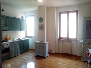 eine Küche mit grünen Schränken und Holzböden in der Unterkunft Appartamento HAPPY DAYS con 1 posto auto privato in Lucca