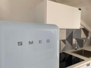 a white kitchen with a sink and a refrigerator at Diano Design&Suite Azur in Diano Marina