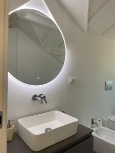 un bagno con un lavandino bianco e uno specchio di Diano Design&Suite Azur a Diano Marina