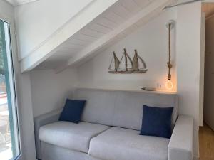 un divano con cuscini blu in soggiorno di Diano Design&Suite Azur a Diano Marina