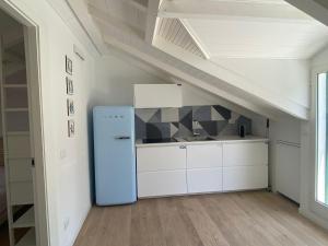 una cucina con un frigorifero blu in una soffitta di Diano Design&Suite Azur a Diano Marina Altre 26 foto