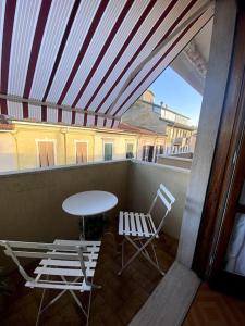 uma varanda com uma mesa e cadeiras e uma mesa em Appartamento in pieno centro - 500 metri dal mare. em Viareggio