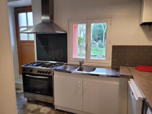 a kitchen with a sink and a stove and a window at Carignan in Carcassonne