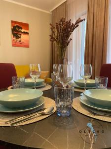 a dining room table with plates and glasses on it at Apartament Olecko Nad Jeziorem in Olecko