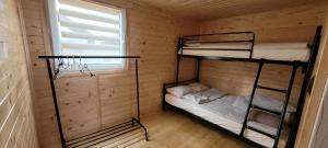 two bunk beds in a wooden cabin with a window at Noclegi u Eli Zator Energylandia in Zator