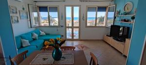 a living room with a blue couch and a table at VillaMargherita2023 in Porto Palo