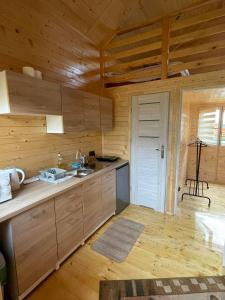 a kitchen with wooden walls and a wooden floor at Noclegi u Eli Zator Energylandia in Zator