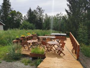 une terrasse en bois avec des tables, des chaises et un grill dans l'établissement Ryhmämajoitus, à Lappeenranta