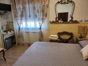 a bedroom with a bed and a mirror and a window at Alloggi Adamo Venice in Oriago Di Mira