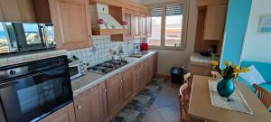 a kitchen with wooden cabinets and a stove top oven at VillaMargherita2023 in Porto Palo +19 photos