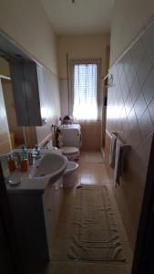 a bathroom with a sink and a toilet and a window at VillaMargherita2023 in Porto Palo