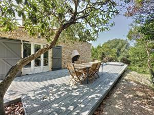 a wooden deck with a table and chairs on it at Villa 2 chambres avec jacuzzi in Bonifacio