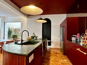 uma cozinha com armários vermelhos e uma grande ilha de cozinha em Maison MAÏTÉ, au cœur de Biarritz em Biarritz