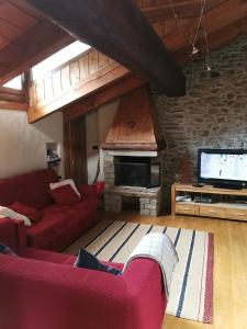a living room with a red couch and a fireplace at Affascinante appartamento ai piedi dell'ovovia in Courmayeur