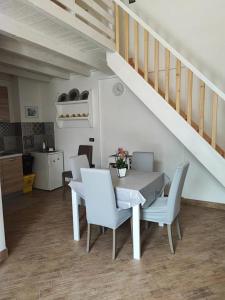 uma sala de jantar com uma mesa branca e cadeiras brancas em Greta Viola House em Squinzano