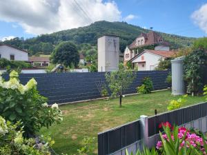 a fence in a yard with a hill in the background at Ferienwohnung Schardt in Annweiler am Trifels