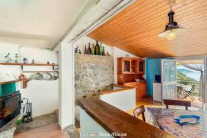 a kitchen with a wooden ceiling and a table at Casa Giulia, Trekking and Nature in Campiglia