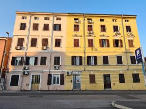 a yellow building with many windows on a street at Nina & Lola in Rijeka