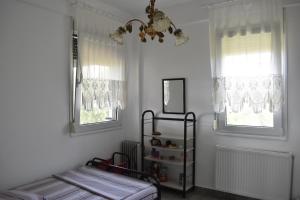 a bedroom with two beds and a chandelier and two windows at Earthly paradise Kariani in Karianí