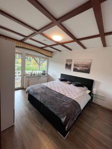 ein Schlafzimmer mit einem großen Bett in einem Zimmer in der Unterkunft Modern und Rustikal mit Kamin Ferienwohnung Kohlert in Bad Berleburg