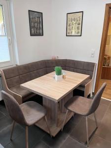 einen Holztisch mit zwei Stühlen und einem Sofa in der Unterkunft Modern und Rustikal mit Kamin Ferienwohnung Kohlert in Bad Berleburg