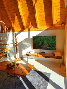 a living room with a large flat screen tv on the wall at Usula Bungalov in Rize