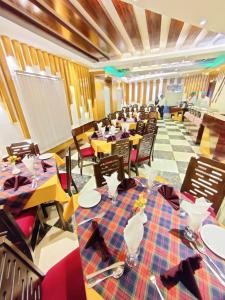 une salle à manger avec des tables, des chaises et un tableau blanc dans l'établissement Shahjadi Resort, à Cox's Bazar