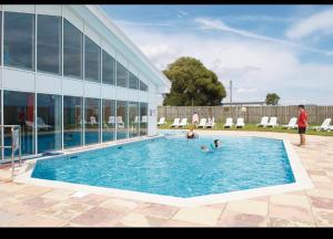 a group of people in a swimming pool next to a building at Rohannah static Caravan Fantastic Family and Friends Holiday in East Mersea